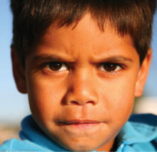 The stern face of a young indigenous boy
